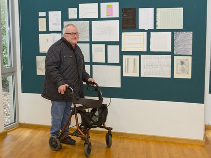 Künstler Gerd Schippel schaut sich die Zeichnungen an - ob auch eine von ihm dabei ist?